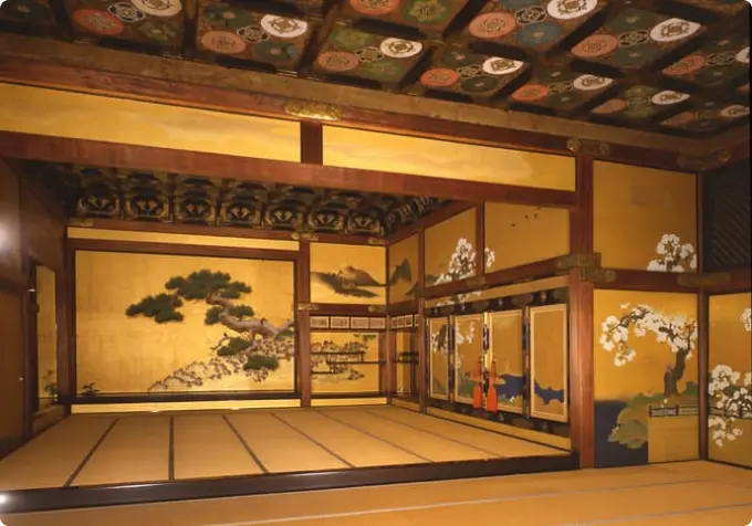 The interior of a magnificent Ninomaru Palace room with tatami mats, gold leaf paintings, and a decorative ceiling.