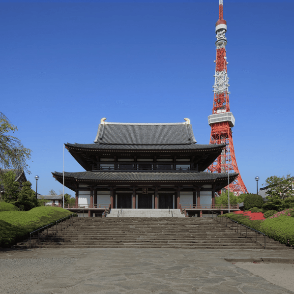 Zojo-ji Temple's main hall viewed from stone steps, with the red and white structure of Tokyo Tower rising sharply in the background against a clear blue sky.
