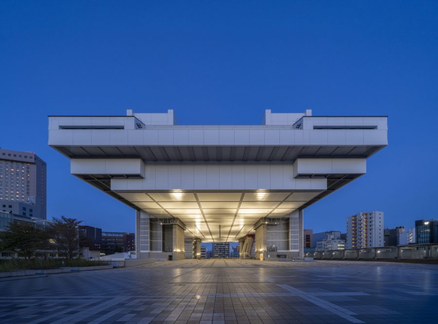 The monumental Edo-Tokyo Museum building at dusk, viewed head-on from the plaza below, illuminated from underneath.