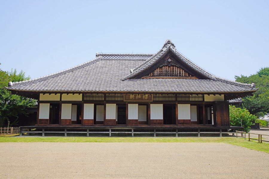 The main building of the Kodokan, a historic Japanese domain school, featuring a large tiled roof and open veranda.