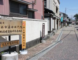 A wooden sign marking the Kaeimon-cho Traditional Building Preservation District and the Nikko Reiheishi Kaido road.