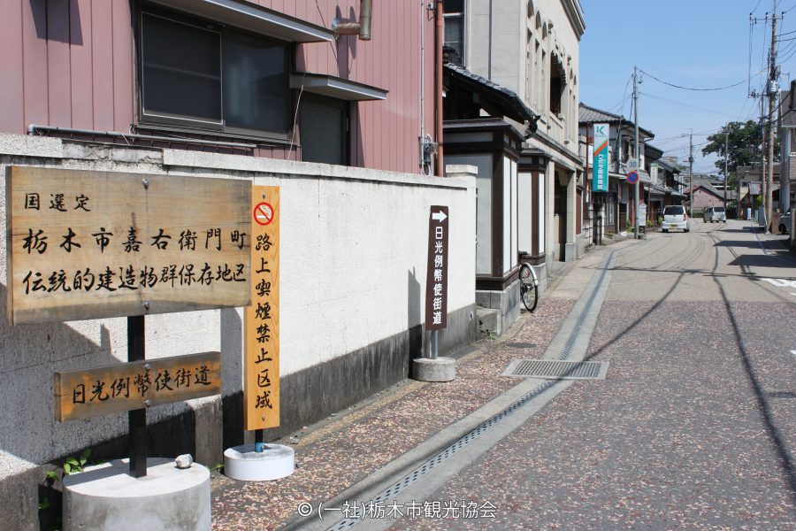 A wooden sign marking the Kaeimon-cho Traditional Building Preservation District and the Nikko Reiheishi Kaido road.