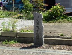 A tall, weathered stone marker engraved with the Japanese characters for "Nikko Reiheishi Kaido."