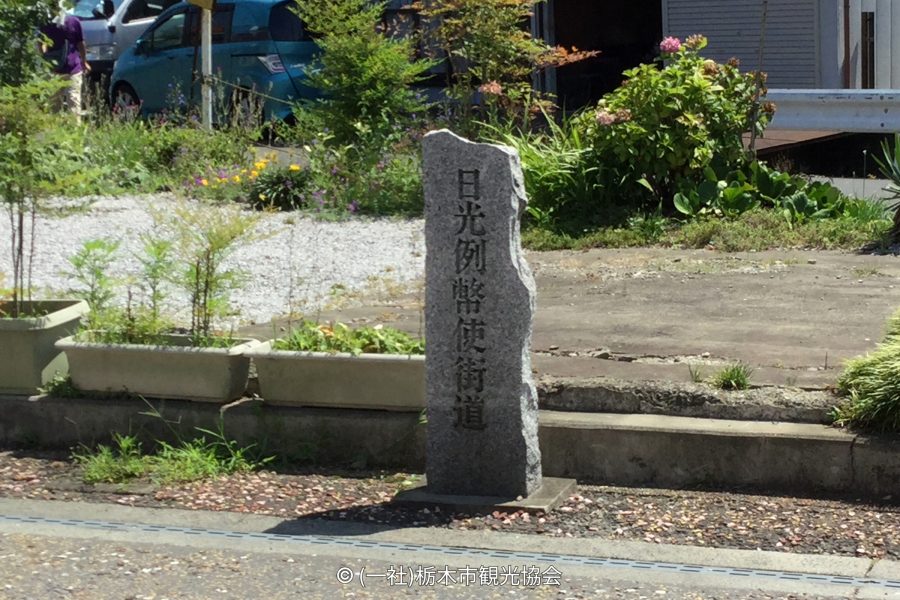 A tall, weathered stone marker engraved with the Japanese characters for "Nikko Reiheishi Kaido."