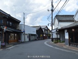 A curving street in the traditional Kaeimon-cho district lined with old Japanese buildings and utility poles.