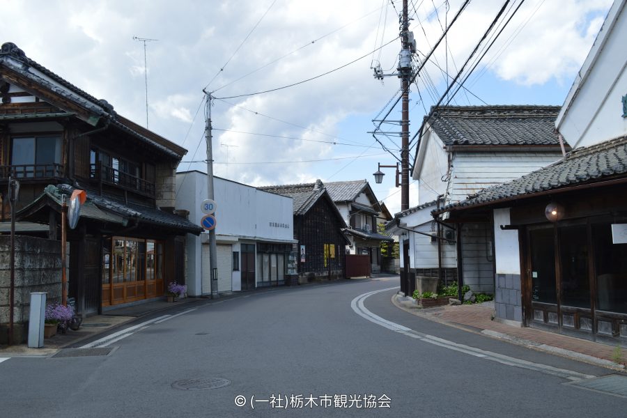 A curving street in the traditional Kaeimon-cho district lined with old Japanese buildings and utility poles.