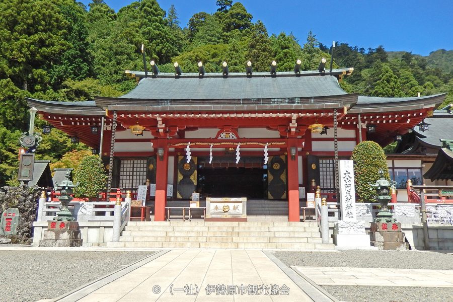 The red and white main hall of Oyama Afuri Shrine at the top of a stone staircase.