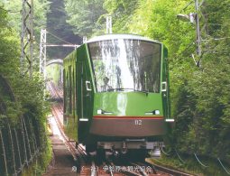 The Oyama Cable Car ascending the steep mountain track through the green forest.