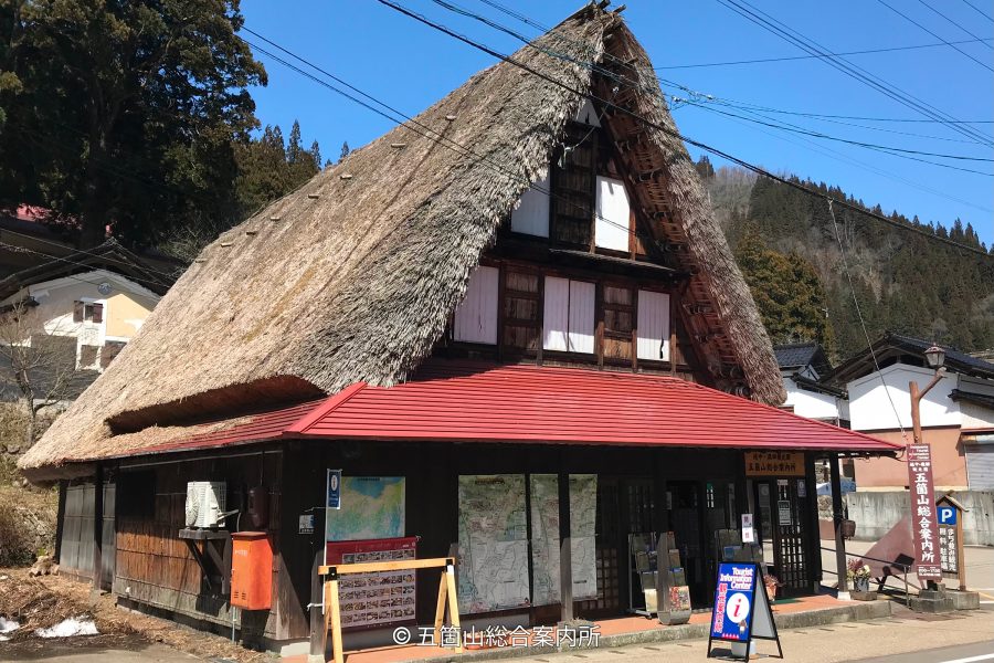 A traditional Gassho-zukuri house modified with a red tiled roof over the lower floor to serve as a tourist information center.