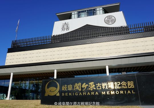 The modern exterior of the Gifu Sekigahara Battlefield Memorial Museum with a large sign and a Japanese crest visible on the top level.