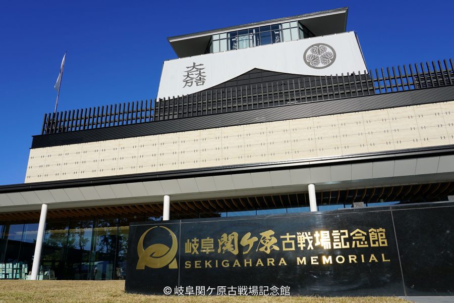The modern exterior of the Gifu Sekigahara Battlefield Memorial Museum with a large sign and a Japanese crest visible on the top level.