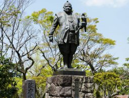A statue of Tokugawa Ieyasu holding a hawk (falconry posture) on a stone pedestal in Sunpu Castle Park.