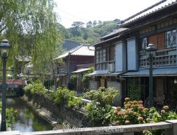 Traditional Japanese buildings with tiled roofs and a small canal lining the historic Perry Road in Shimoda.