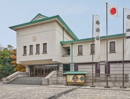 The exterior of the Tokugawa Art Museum, an Imperial Crown style building with multiple flags bearing the Tokugawa crest.