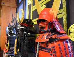 A close-up display of colorful samurai armor (yoroi), including a striking red suit, inside the castle museum.