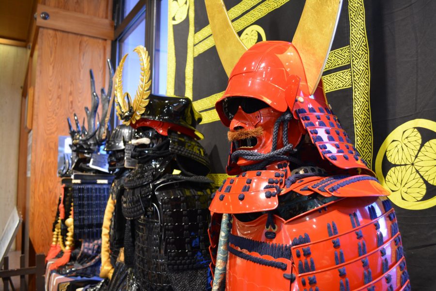 A close-up display of colorful samurai armor (yoroi), including a striking red suit, inside the castle museum.
