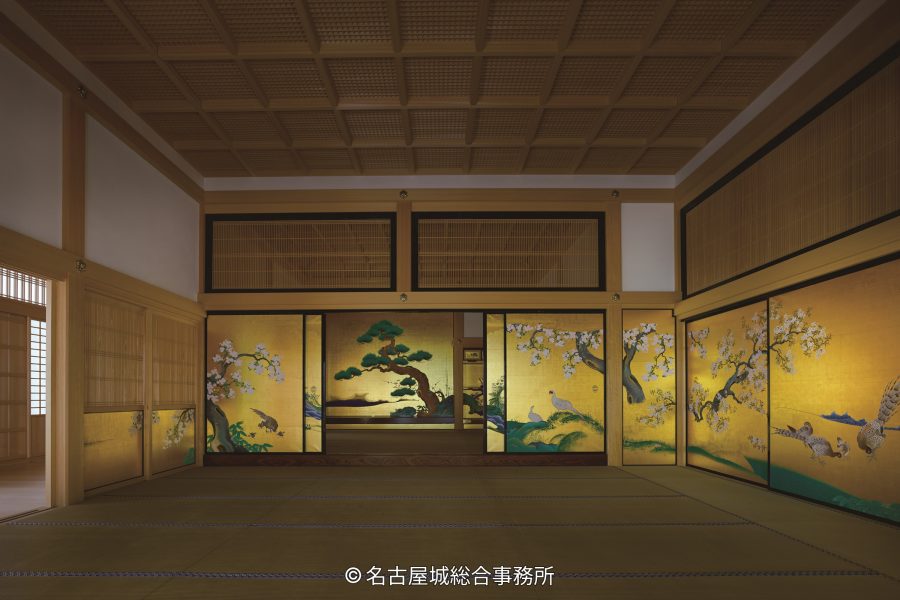 The interior of a room in the reconstructed Honmaru Palace, featuring tatami mats, a coffered ceiling, and magnificent gold-leaf sliding doors (fusuma-e).