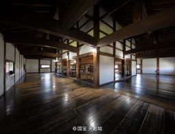 The interior of the Inuyama Castle keep with a wide, dark, polished wooden floor and massive exposed wooden beams.