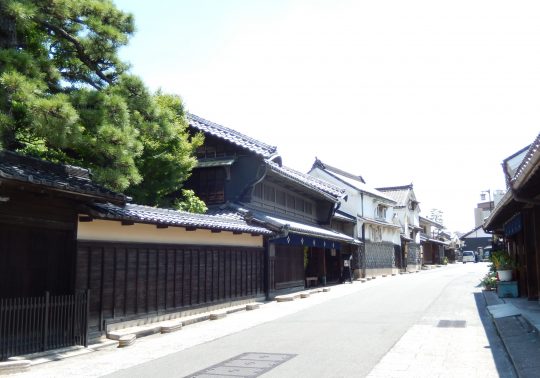 The preserved Edo period townscape of Arimatsu, lined with traditional wooden buildings and black tiled roofs.