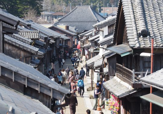 High-angle view of a street crowded with people and lined by traditional houses in Seki-juku.