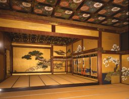 The interior of a magnificent Ninomaru Palace room with tatami mats, gold leaf paintings, and a decorative ceiling.