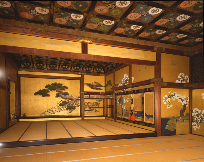 The interior of a magnificent Ninomaru Palace room with tatami mats, gold leaf paintings, and a decorative ceiling.
