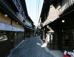 A narrow, stone-paved street in Arima Onsen, lined with preserved traditional wooden buildings, giving a historic, quiet atmosphere.