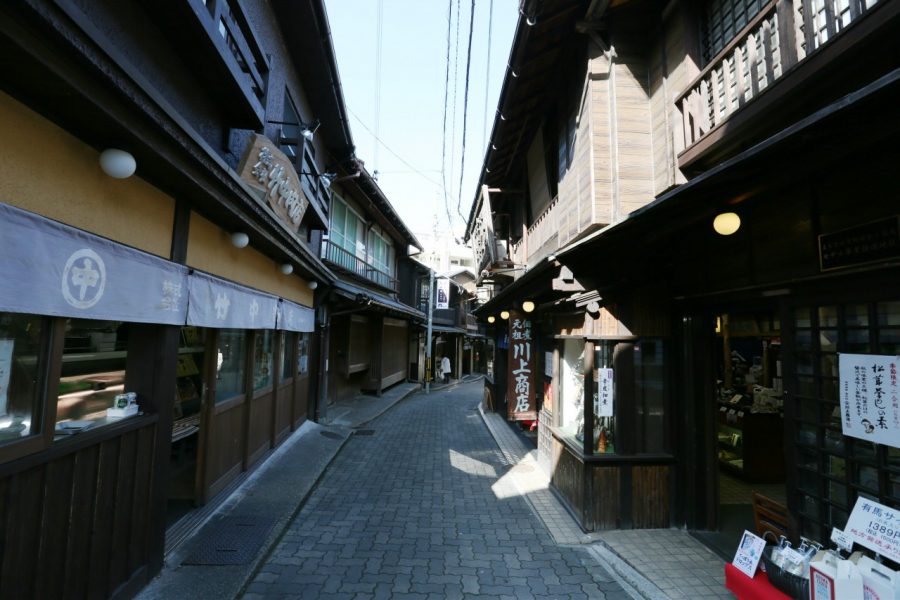 A narrow, stone-paved street in Arima Onsen, lined with preserved traditional wooden buildings, giving a historic, quiet atmosphere.