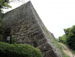 A massive, high stone wall (ishigaki) of Marugame Castle, showcasing its steep slope and rugged construction.