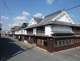 The preserved streetscape of Yame Fukushima, showing two-story traditional merchant houses with white plaster walls and tiled roofs.