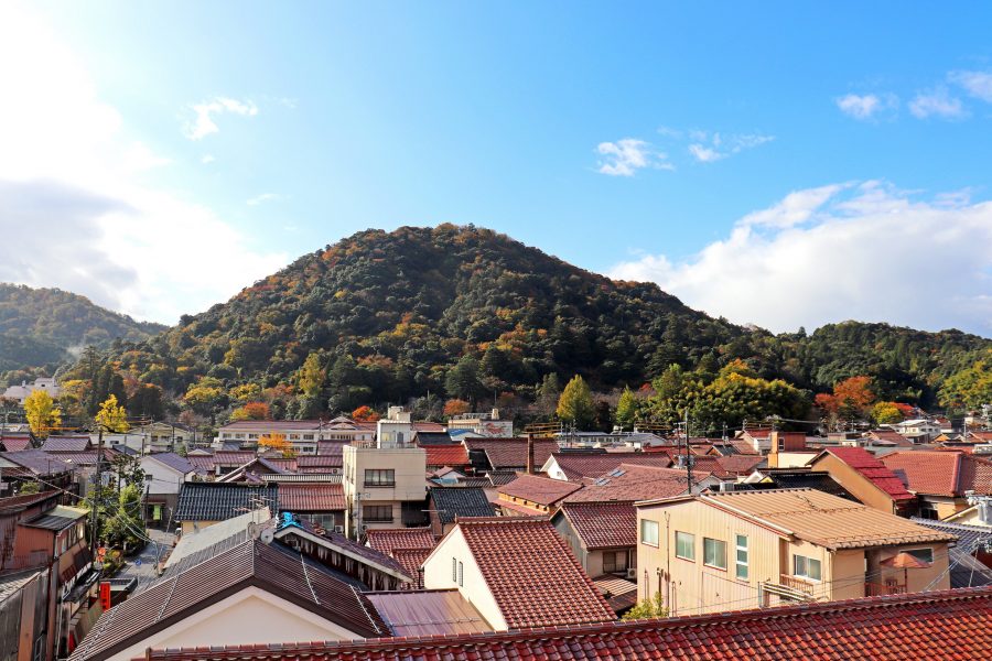 View of Mount Utsubuki with autumn foliage, rising above the traditional tiled rooftops of Kurayoshi city in Tottori Prefecture.