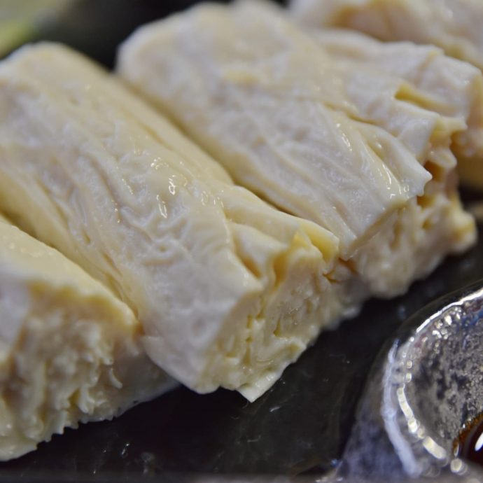 Slices of yuba (tofu skin) on a plate.
