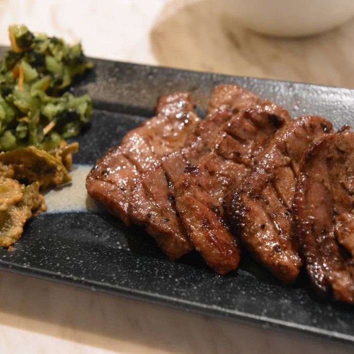 Grilled beef tongue slices on a plate.