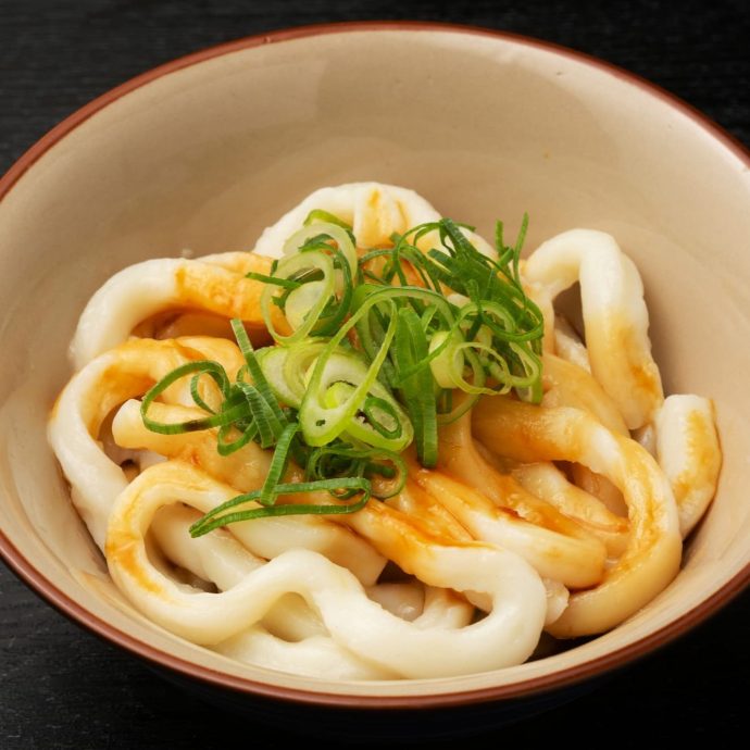 Ise udon noodles in a bowl with green onions.