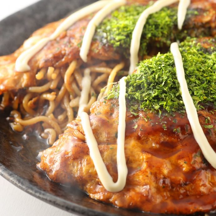 Hiroshima-style okonomiyaki on a grill.