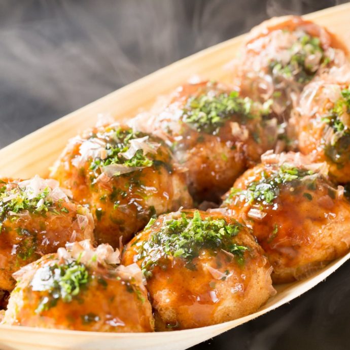 Takoyaki (octopus balls) in a boat-shaped dish.