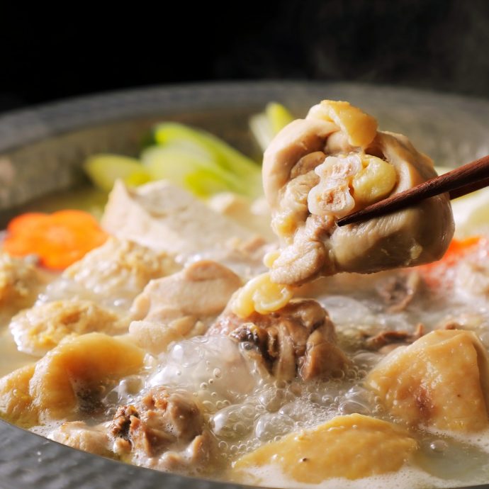Mizutaki (chicken hot pot) cooking in a nabe pot.