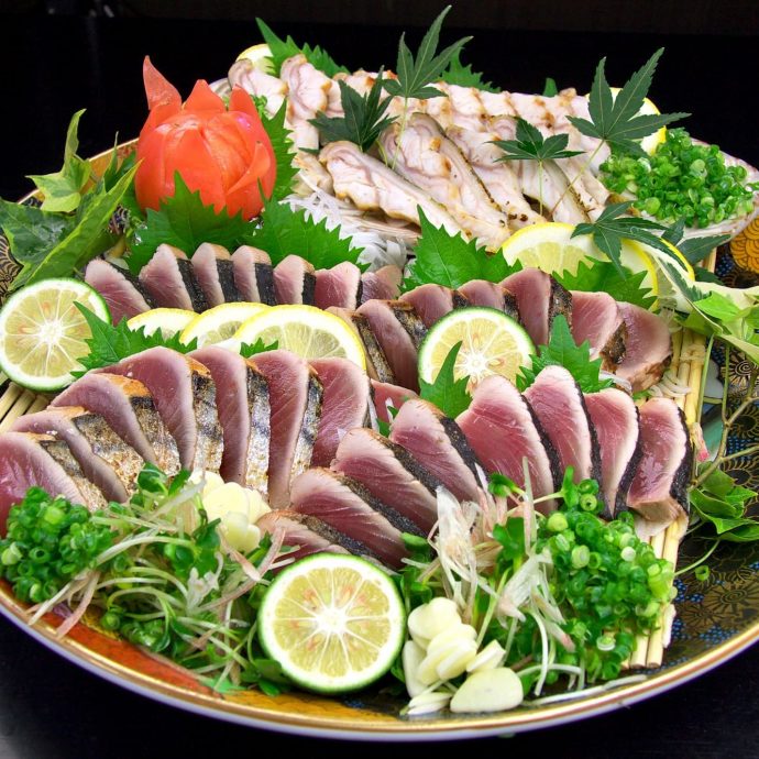 Katsuo-no-tataki (seared bonito) slices on a platter.