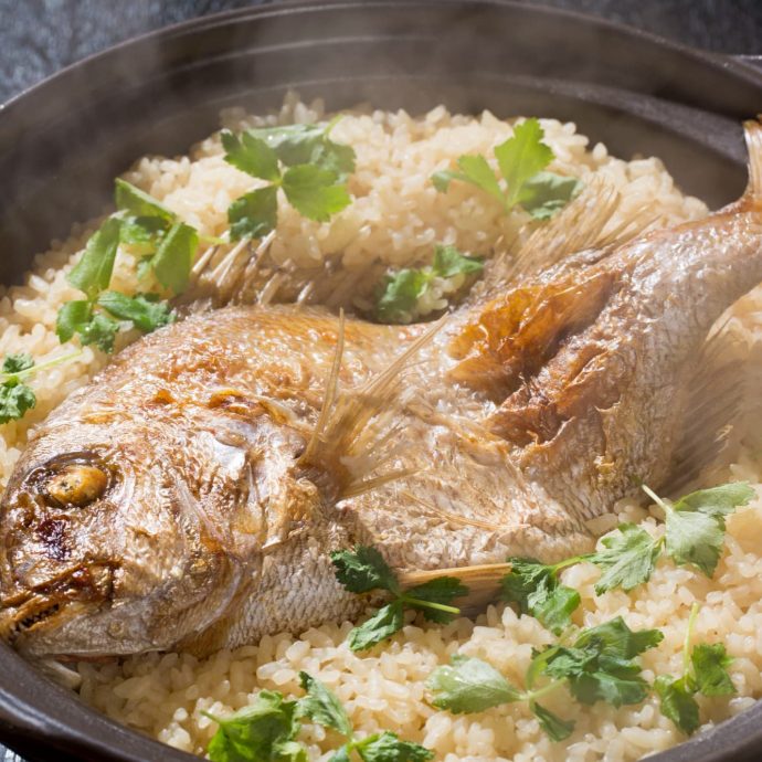 Tai-meshi (sea bream rice) cooking in a clay pot.