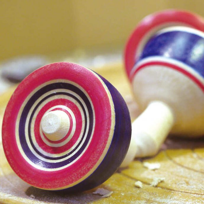 Traditional Oyama Koma spinning tops with red and blue stripes.
