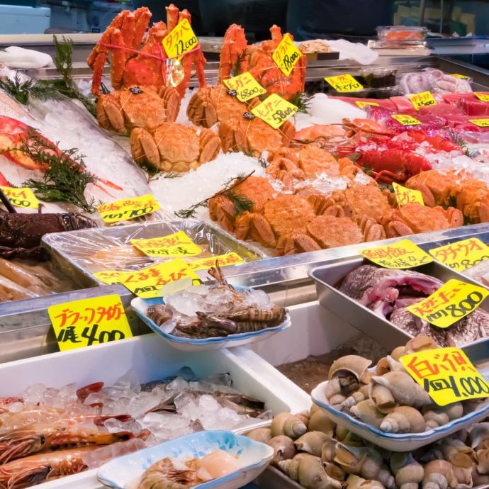 Fresh seafood, including crabs and fish, displayed at Tsukiji fish market.