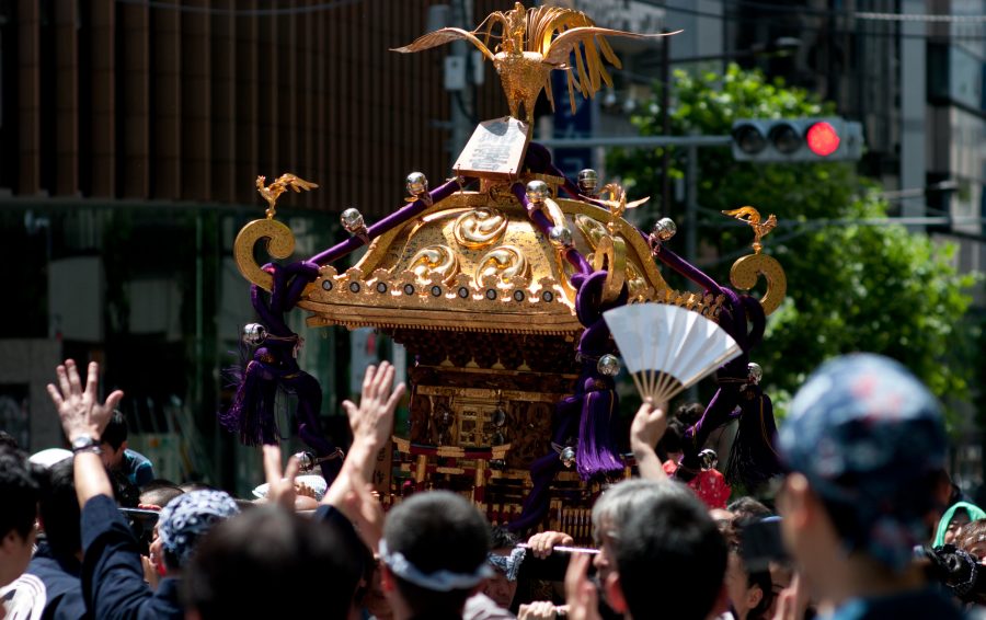 Modern-day Mikoshi of the Kanda Festival. A magnificent portable shrine (mikoshi), adorned with gold and topped with a golden phoenix, is being carried through the streets. The energy of the crowd reaching out to the mikoshi echoes the vibrancy depicted in the Edo-period Ukiyo-e scroll we saw earlier.