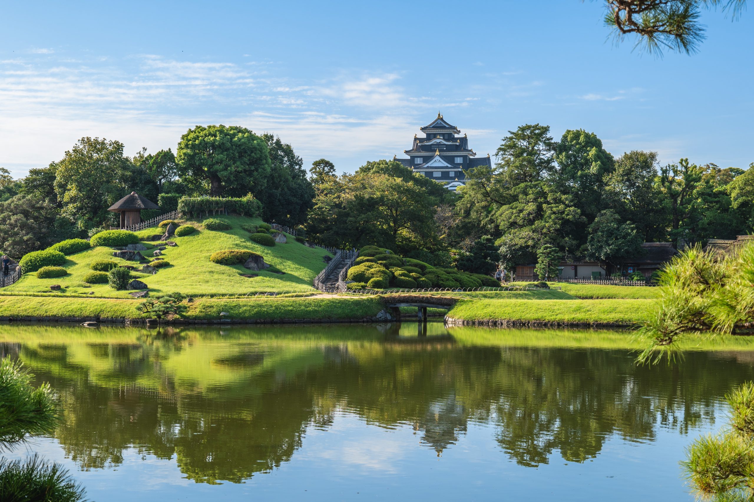 View of Okayama Korakuen Garden featuring a pond and Okayama Castle in the background.